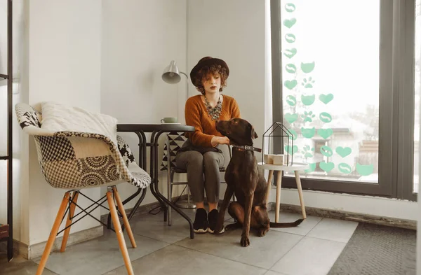 Gadis menarik dengan rambut keriting dengan pakaian bergaya duduk di coz — Stok Foto