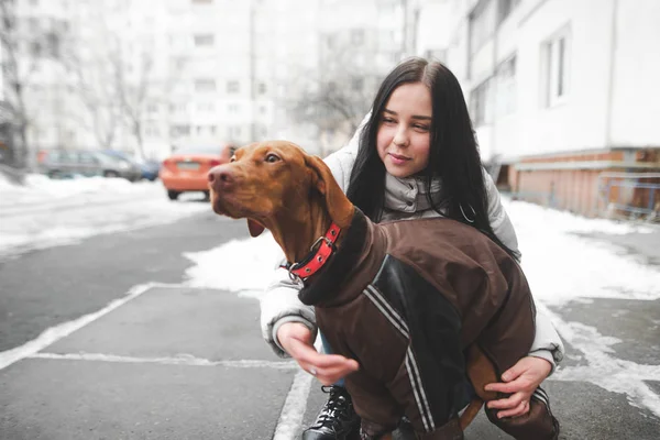 Gyönyörű mosolygós lány meleg téli ruhákban tart egy öltözött do — Stock Fotó