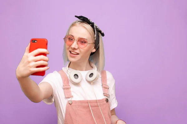 Κορίτσι με φωτεινά ρούχα και κομψά ακουστικά στέκεται σε ένα γουργουρητό — Φωτογραφία Αρχείου
