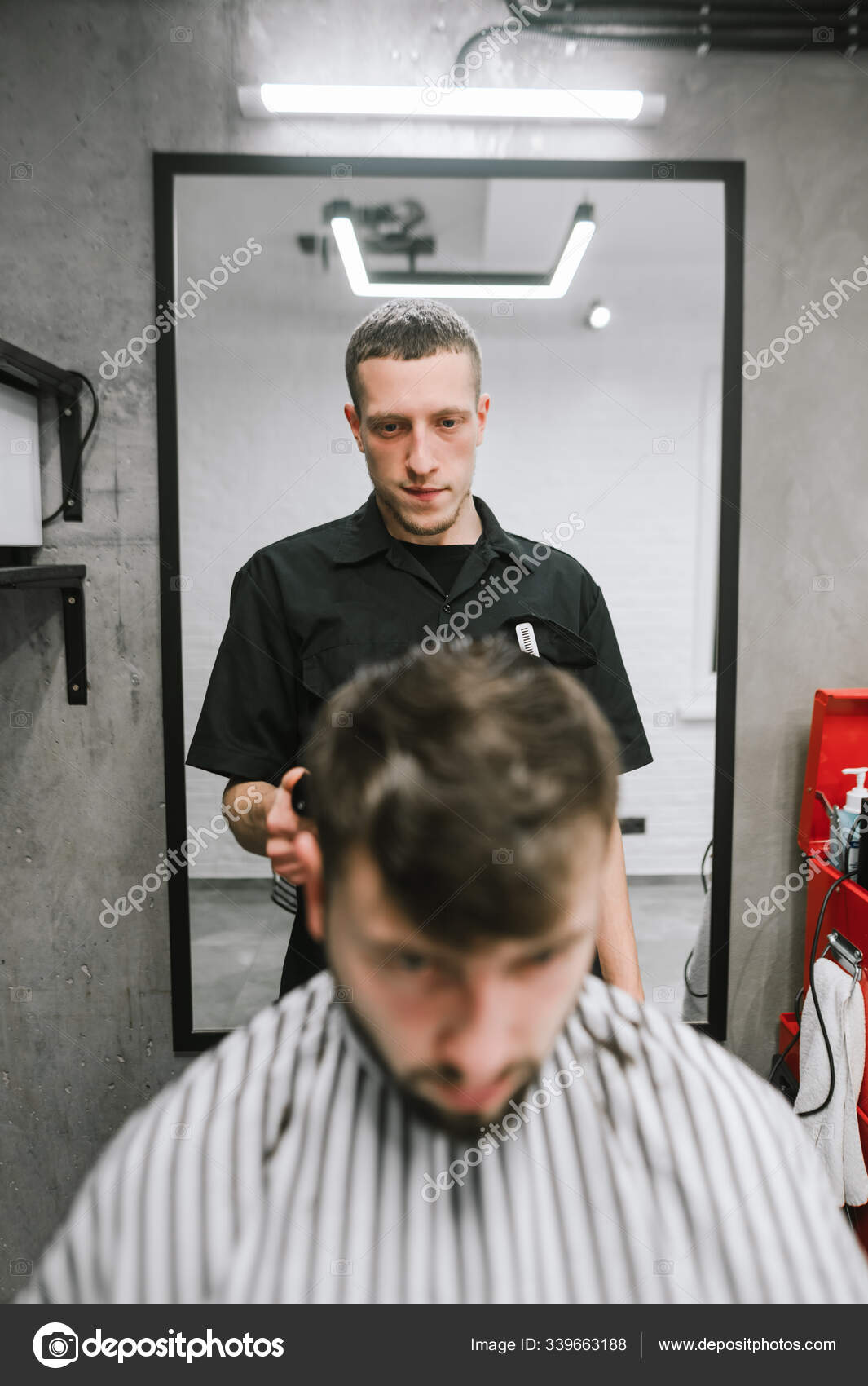 Vertical portrait of a barber cuts a bearded client in a men's hairdresser, looking intently at the man's hair. Male hairdresser creates hairstyle. Barbershop concept Stock Photo by ©bodnarphoto 339663188 Vertical portrait of a barber cuts a bearded client in a men's hairdresser, looking intently at the man's hair. Male hairdresser creates hairstyle. Barbershop concept Stock Photo by ©bodnarphoto 339663188