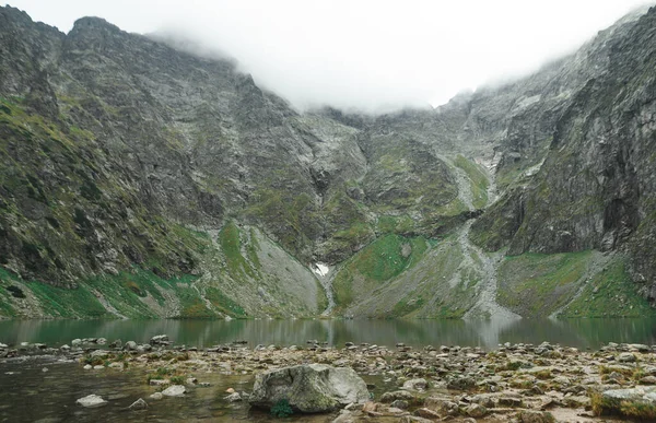 Górskie jezioro na szczycie góry. Skały na brzegu górskiego jeziora. Nierealistyczny pogląd na naturę. Tatry Zachodnie — Zdjęcie stockowe