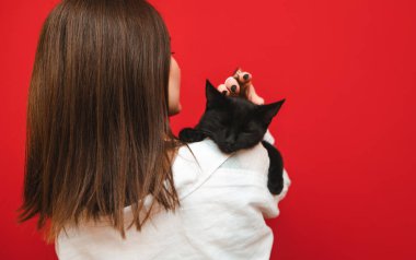 Kadın bir kediyi omuzlarının üstünde okşar, siyah yünü okşar, kedi uyur. Siyah kedi bir kızın omuzlarında uyur, arkadan manzara. Sahibi sevdiği kediyi kucaklayıp ütülüyor..