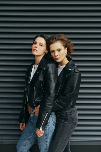 Retrato de moda de duas meninas elegantes em pé contra um w preto — Fotografia de Stock