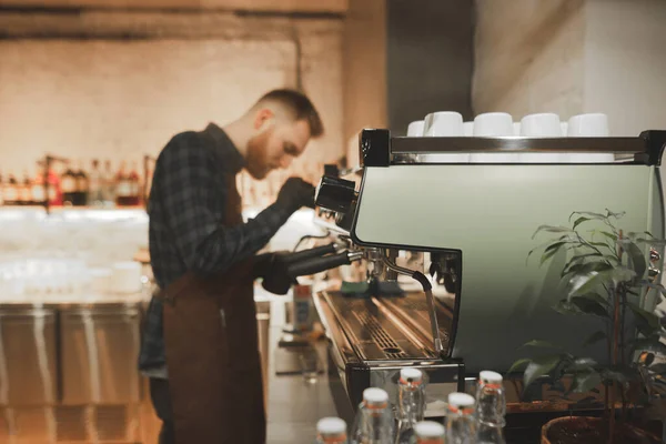 Barista barbudo homem vapor leite em um machi de café profissional — Fotografia de Stock