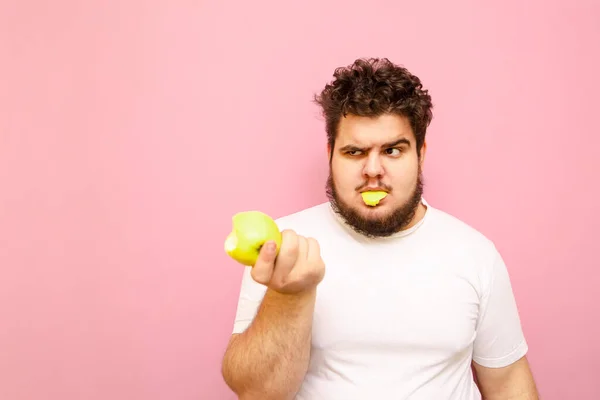 Портрет Смешного Молодого Человека Избыточным Весом Поедающего Зеленое Безвкусное Яблоко — стоковое фото