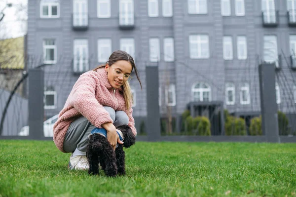 Lycklig Flicka Sitter Den Gröna Gräsmattan Och Smeker Hunden Med — Stockfoto