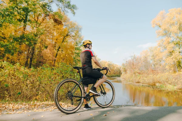 Fotografie Cyklisty Stojícího Břehu Podzimního Jezera Odpočívajícího Cyklistickém Dresu Helmě — Stock fotografie