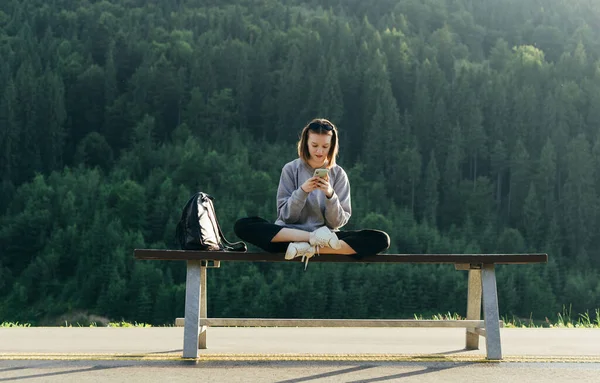 Attractive Girl Casual Clothes Sits Bench Backpack Uses Smartphone Background — Stock Photo, Image