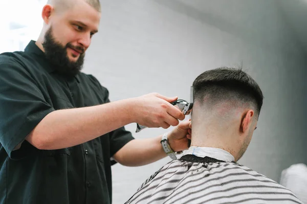 Positive Male Hairdresser Cuts Client Hair Clipper His Hand Smiles — Stock Photo, Image