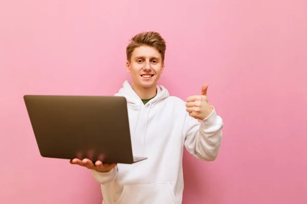 Happy Young Man Stands Pink Background Laptop His Hand Looks — Stock Photo, Image