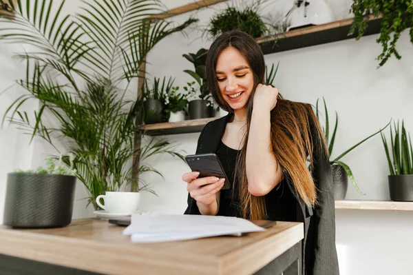 Die Schöne Junge Geschäftsfrau Sitzt Mit Einer Tasse Kaffee Und — Stockfoto