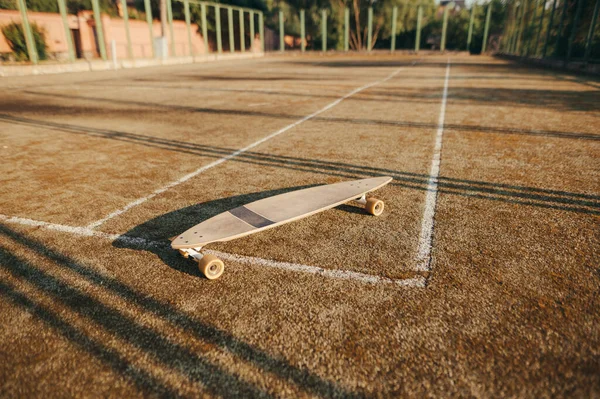 ロングボードは古いテニスコートに立っている スケートの概念 スケートのコンセプトコピースペース — ストック写真