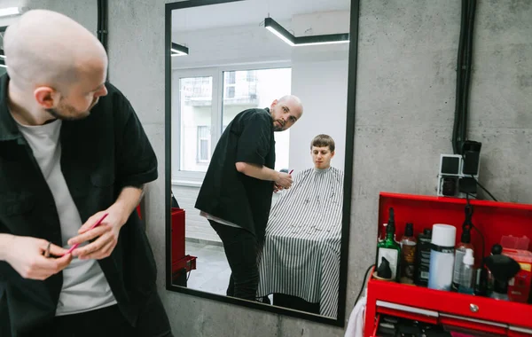 Male Hairdresser Cuts Beautiful Young Man Male Hairdresser Looks Mirror — Stock Photo, Image