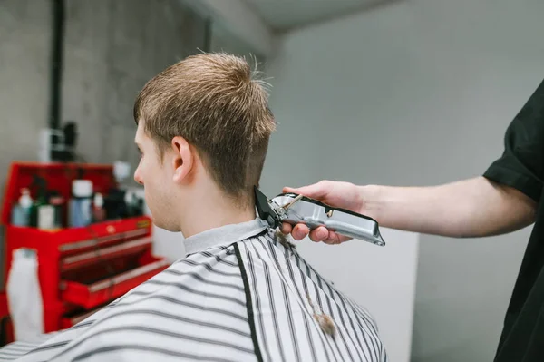 Männlicher Friseur Schneidet Jungen Mann Die Haare Mit Einem Haarschneider — Stockfoto