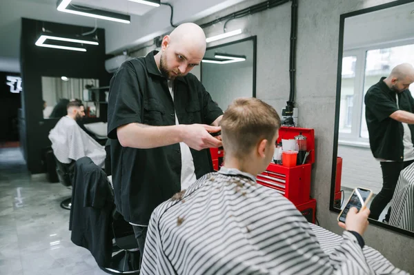 Der Kunde Sitzt Friseurstuhl Und Bedient Sich Eines Smartphones Wenn — Stockfoto