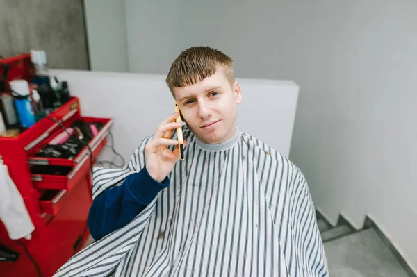 Una Joven Barbería Sonriente Sienta Una Silla Habla Por Teléfono — Foto de Stock