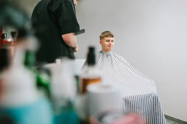 Positivo Giovane Siede Una Sedia Barbiere Riceve Taglio Capelli Lieto — Foto Stock