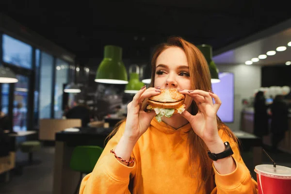 패스트푸드 버거를 얼굴로 시선을 돌리는 귀여운 소녀의 귀여운 아가씨가 햄버거를 — 스톡 사진