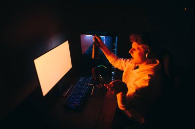 Kulaklıklı huysuz genç bir adam ve elinde bir şişe birayla geceleri bilgisayar kullanıyor, kameraya bakıyor ve bulmaca gibi hareketler yapıyor. Tatminsiz oyuncu oyunlar oynar ve bira içer.