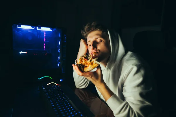 Jonge Gamer Zit Thuis Aan Tafel Aan Computer Eet Pizza — Stockfoto