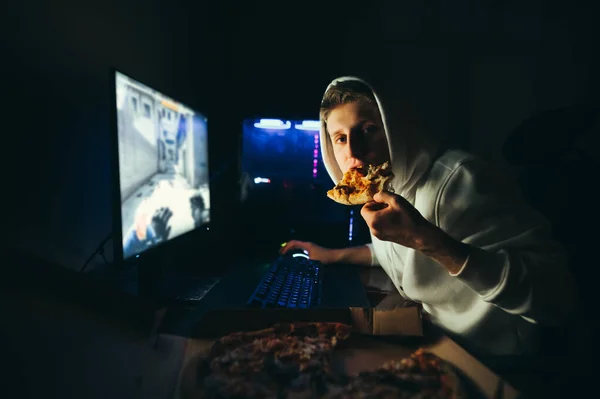 Young Man Sits Night Table Next Computer Eating Slice Pizza — Stock Photo, Image