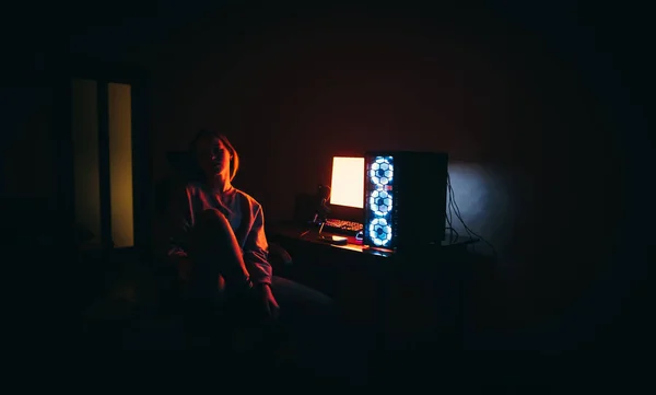 Foto Noturna Menina Atraente Sentado Cadeira Perto Computador Luz Vermelha — Fotografia de Stock