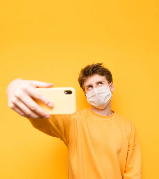 Serious Young Man Mask Coronavirus Yellow Sweater Makes Selfie Smartphone — Stock Photo, Image