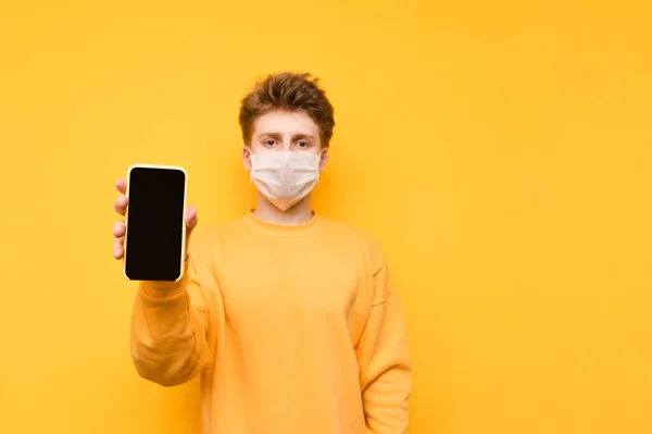 Handsome Guy Yellow Sweatshirt Protective Gauze Mask Stands Orange Background — Stock Photo, Image