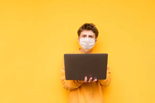 Surprised Young Man Medical Mask Stands Laptop His Hands Looks — Stock Photo, Image