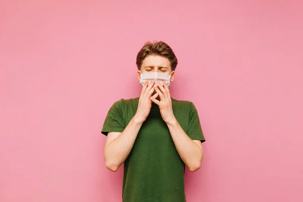 Cara Doente Uma Máscara Médica Espirra Fundo Rosa Jovem Com — Fotografia de Stock