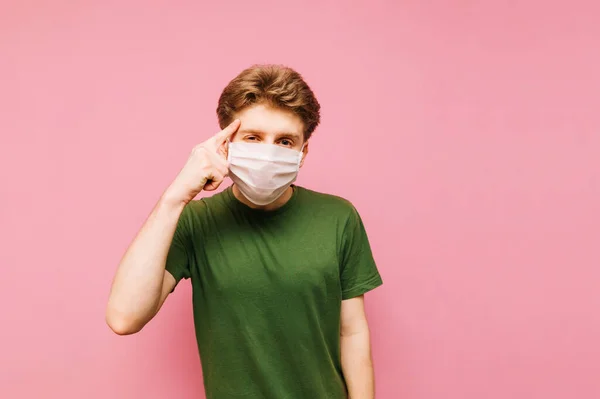 Jeune Homme Dans Masque Médical Tient Sur Fond Rose Regarde — Photo