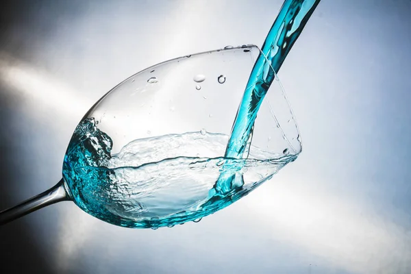 Spray colored water in a glass — Stock Photo, Image