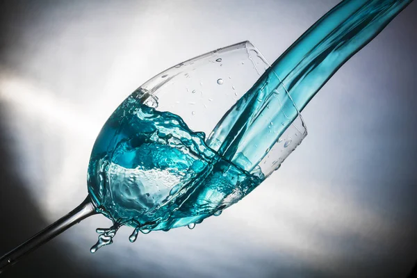 Spray colored water in a glass — Stock Photo, Image