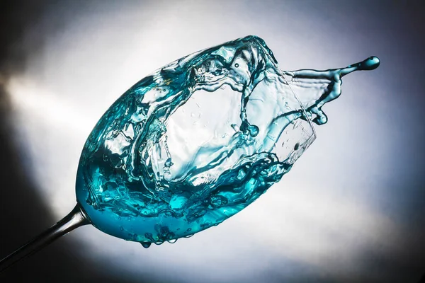 Spruzzare acqua colorata in un bicchiere — Foto Stock