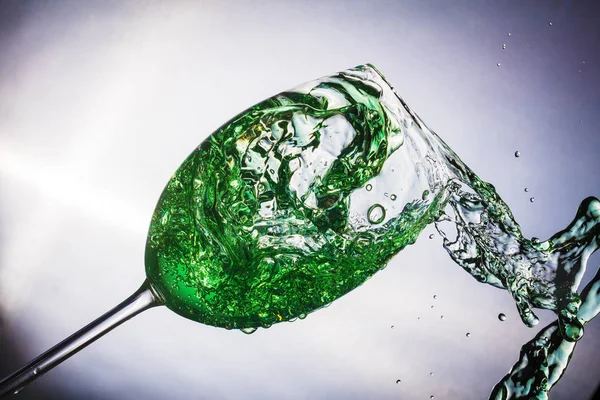 Spray colored water in a glass — Stock Photo, Image