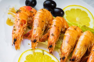 Beyaz tabakta kızartılmış langostinler stüdyoda fotoğraflandı.