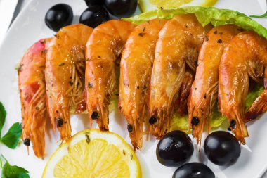 Beyaz tabakta kızartılmış langostinler stüdyoda fotoğraflandı.