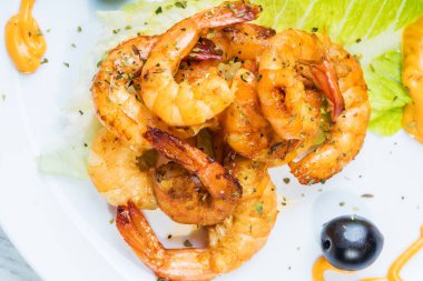 Beyaz tabakta kızartılmış langostinler stüdyoda fotoğraflandı.