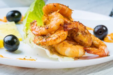 Beyaz tabakta kızartılmış langostinler stüdyoda fotoğraflandı.