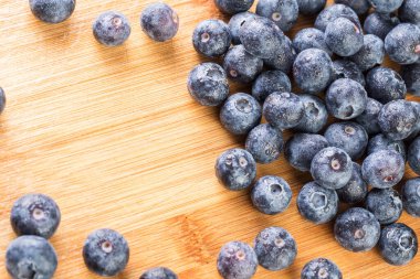 Beyaz tabakta güzel taze yaban mersini. Ahşap arka planda fotoğraflanmış.
