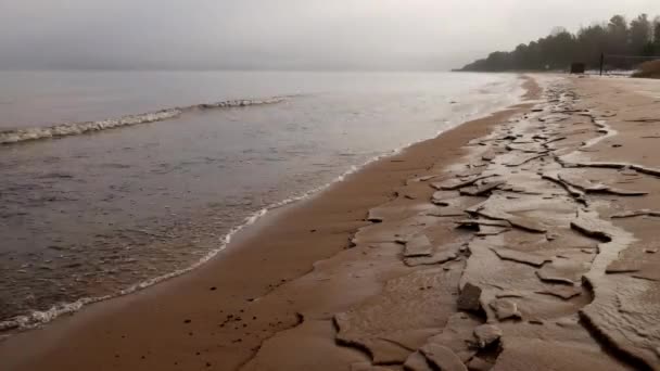 Idő körök gyönyörű hullámok kúszik a homokos tengerparton a köd. — Stock videók