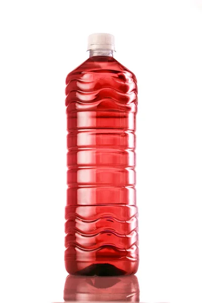 Bebida vermelha em frasco de plástico sobre fundo branco — Fotografia de Stock