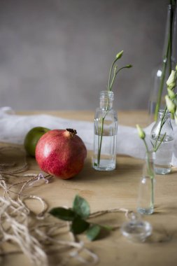 Nar ve ahşap masa şişesinde çiçek