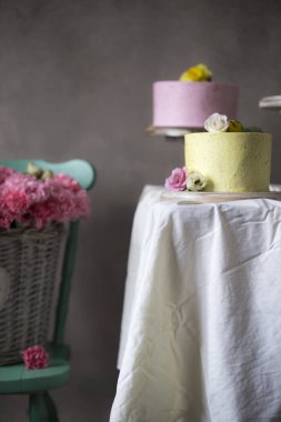 Renkli bahar çiçekleri sepeti renkli Paskalya kek ile dekore edilmiş kapatmak için sandalye tatil tabloda yer 