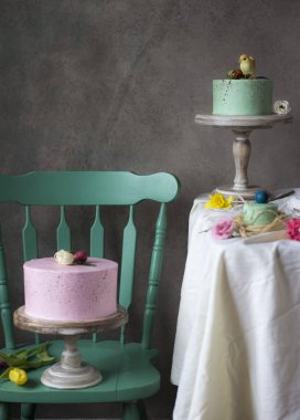 Paskalya masa dekorasyonu, bahar çiçekleri ve tatil masada boyalı yumurta ile lezzetli ev yapımı kekler 