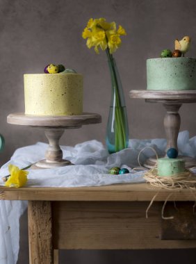 Paskalya masa dekorasyonu, bahar çiçekleri ve tatil masada boyalı yumurta ile lezzetli ev yapımı kekler 