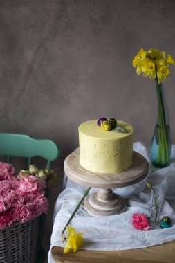Paskalya masa dekorasyonu, lezzetli ev yapımı kek bahar çiçekleri ve tatil masada boyalı yumurta. Sepeti taze yakın tablo Easter yerleştirilir