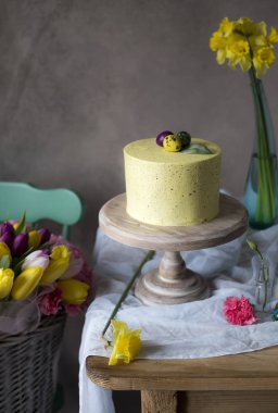 Paskalya masa dekorasyonu, lezzetli ev yapımı kek bahar çiçekleri ve tatil masada boyalı yumurta 