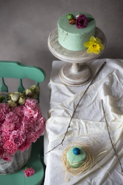 イースター テーブルの装飾 春の花と休日テーブルに塗られた卵とおいしい自家製ケーキ フレッシュのバスケットは イースター テーブルの近くに配置 — ストック写真