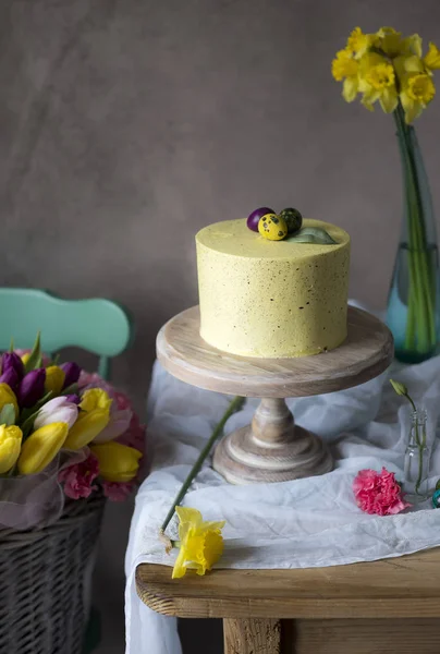 Paskalya masa dekorasyonu, lezzetli ev yapımı kek bahar çiçekleri ve tatil masada boyalı yumurta 